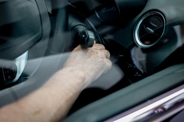 A person is opening a car door with a key.