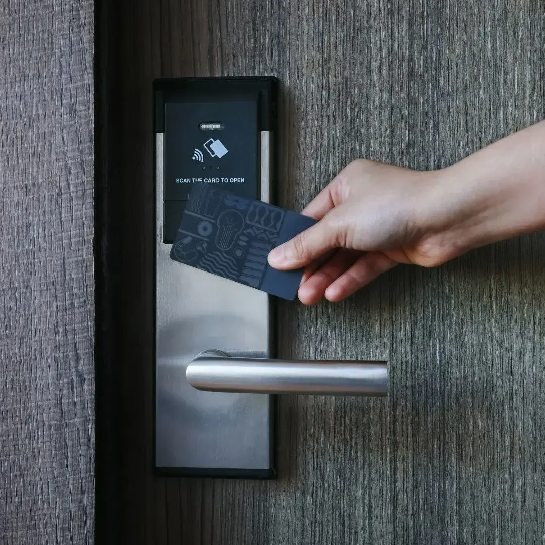 Person using an RFID key card to unlock a smart lock on a residential door in Montgomery Person using an RFID key card to unlock a smart lock on a residential door in Montgomery